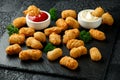 Crispy Battered scampi nuggets with ketchup and mayonnaise on rustic stone board.