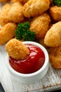 Crispy Battered scampi nuggets with ketchup on white wooden board
