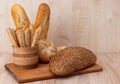 Crispy bread sticks with sesame seeds and bran bread on a wooden board. French baguettes. Different breeds on wooden background
