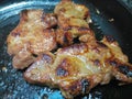 Two cuts of pork shoulder sizzling in oil