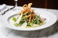 crispy calamari atop caesar salad with shaved parmesan