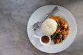 Crispy Chicken with Basil In a white circular dish Placed on a marble table