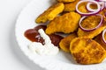 Crispy chicken nuggets in the plate with onion rings,ketchup,mayonnaise and fork. Royalty Free Stock Photo