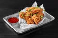 Crispy chicken wings fried in batter with sweet chili sauce on metal tray Royalty Free Stock Photo