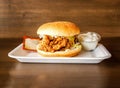 Crispy Chicken Zinger Burger with ketchup and mayonnaise dip served in dish isolated on wooden background side view of indian
