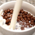 Crispy chocolate balls with milk pouring in bowl. Delicious breakfast. Dairy and cereal products. Close-up shot. Soft Royalty Free Stock Photo