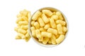Crispy corn sticks spill out of the bowl isolated on white background. Top view Royalty Free Stock Photo