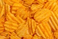 Crispy corrugated potato chips background. Junk food