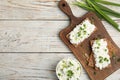 Crispy crackers with cottage cheese and green onion on white wooden table, flat lay. Space for text Royalty Free Stock Photo