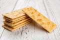 Crispy crackers stacked up on white wood