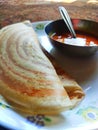 2 crispy double yummy hot tastey dosa with hot sambhar in white plate and silver utensils and spoon