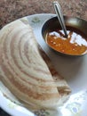 2 crispy double yummy hot tastey dosa with hot sambhar in white plate and silver utensils and spoon