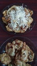 Crispy fried banana with grated parmesan cheese on the plate. Fried potato pancakes with grated parmesan cheese on plate.