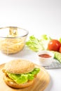 Crispy fried chicken burger on Round Wood plate served with french fries and ketchup. Royalty Free Stock Photo