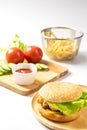 Crispy fried chicken burger on Round Wood plate served with french fries and ketchup. Royalty Free Stock Photo