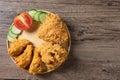 Crispy fried chicken on Round Wood plate served with cucumber, tomato and ketchup on wooden background. Royalty Free Stock Photo