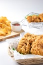 Crispy fried chicken on Sieve and wicker basket serve with cucumber and potato chips on Wood cutting board serve with ketchup Royalty Free Stock Photo