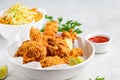 Crispy fried chicken in a white bowl with cole slaw salad and sauce