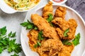 Crispy fried chicken in a white bowl with cole slaw salad and sauce