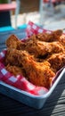 Crispy fried chicken wings on red checkered paper in metal tray Royalty Free Stock Photo