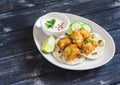 Crispy fried fish on a homemade tortilla on a wooden background