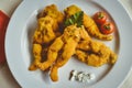 Crispy fried frog legs on a white plate