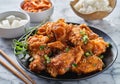 Crispy fried korean chicken wings in galbi sauce with pickled radish, kimchi, and rice side dishes