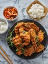 Crispy fried korean chicken wings in galbi sauce with pickled radish, kimchi, and rice side dishes