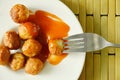 Crispy fried pork ball dressing chili sauce stabbing in fork