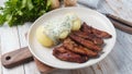 Crispy fried pork with creamy parsley sauce and boiled potato in the plate on the table or stegt flÃÂ¦sk