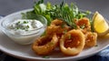Crispy fried squid rings with lemon and tartar sauce for seafood lovers Royalty Free Stock Photo