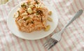 Crispy fried thin rice noodles with coconut cream topping peanut and slice lemon leaf on plate