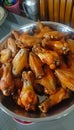 Crispy golden chicken wings fried in sizzling oil, skin glistening with perfection