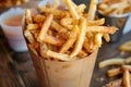 Crispy golden french fries in paper cone