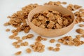 Crispy healthy dry cereal flakes in a wooden bowl on white background