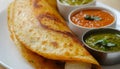 Crispy indian dosa with assorted chutneys on a white plate Royalty Free Stock Photo
