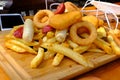 Crispy onion rings, sauce and french fries on table Royalty Free Stock Photo