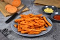 Crispy orange sweet potato fries on gray plate
