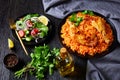 Chicken quarters with tomato rice on a black plate