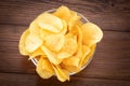 Crispy potato chips in bowl on wooden background, top view Royalty Free Stock Photo