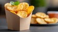 Crispy Potato Chips in a Container with Basil Leaf Garnish Royalty Free Stock Photo