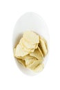 Crispy potato chips in a white bowl. Appetizing popular snack. Top view. Close-up. Isolated on white background Royalty Free Stock Photo