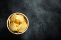 Crispy potato chips in a white bowl on black background Royalty Free Stock Photo