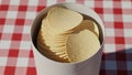 Crispy Potato Chips in a White Container on a Red and White Checkered Tablecloth Royalty Free Stock Photo
