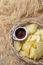 Crispy potato chips in a wicker bowl with ketchup. Royalty Free Stock Photo