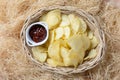 Crispy potato chips in a wicker bowl with ketchup. Royalty Free Stock Photo