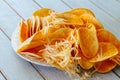 Crispy potato chips in a wicker bowl on old kitchen wood table Royalty Free Stock Photo