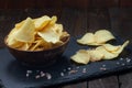 Crispy potato chips in a wooden bowl on old kitchen table Royalty Free Stock Photo