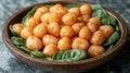 Crispy potato dumplings on spinach in wooden bowl on textured surface Royalty Free Stock Photo