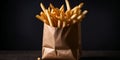 crispy potato French fries on paper bag on a dark background